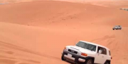 Toyota FJ Cruiser летит через песчаную дюну